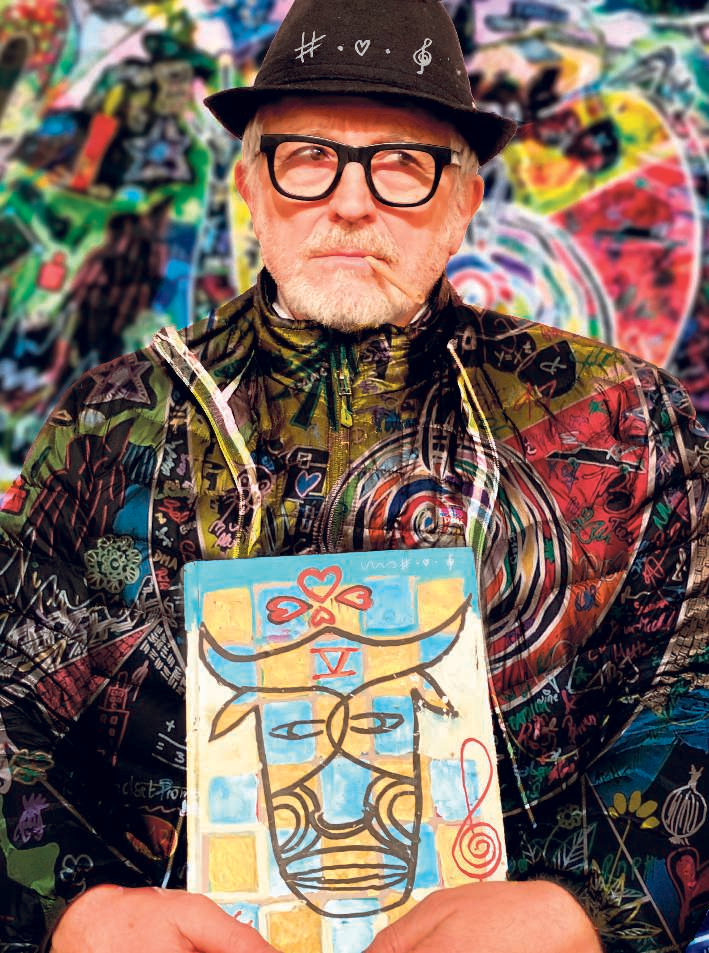 Lars H.U.G. med kunstværk og farverige illustrationer. Foto: Niklas Konoy Mortensen.